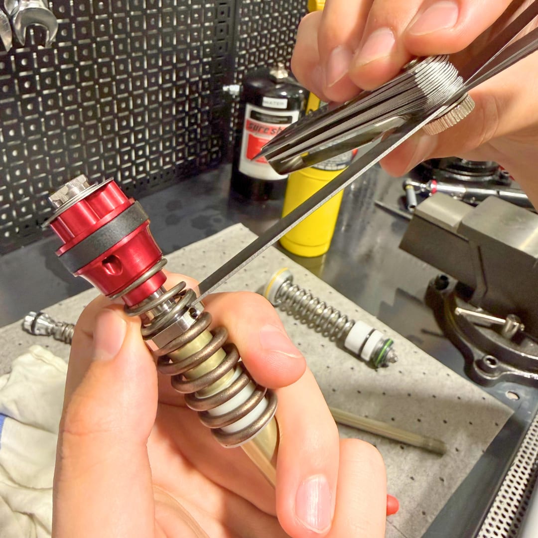 Feeler gauges between the spring and the base of the TAP
