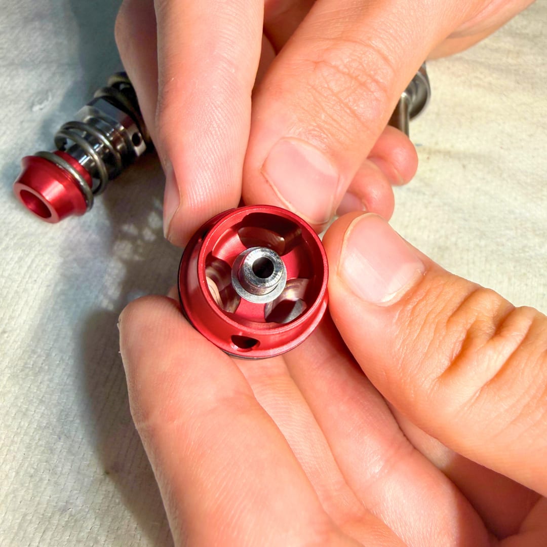Spacer shim seated in the recessed end of the piston